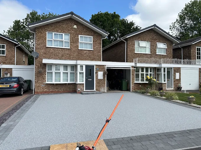 Grey resin bound driveway across the front of a detached house