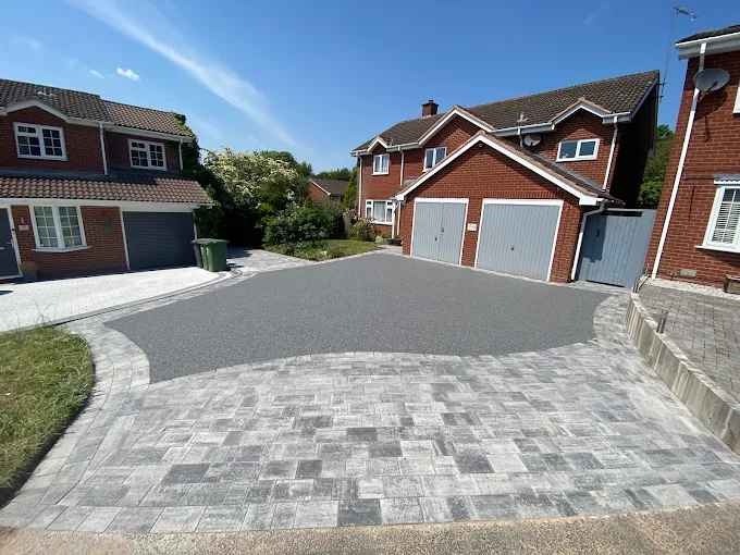 Dark driveway finished with a grey block paved apron